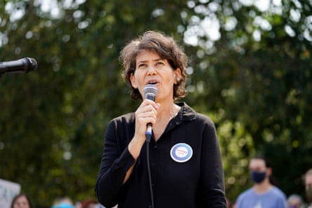 a woman speaks into a microphone outside
