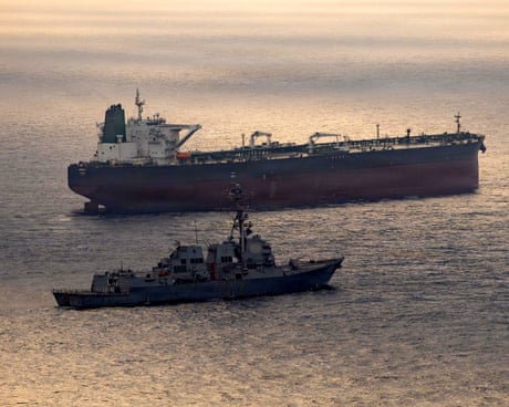 A US destroyer warship and an Iran-flagged crude oil tanker vessel in the strait of Hormuz
