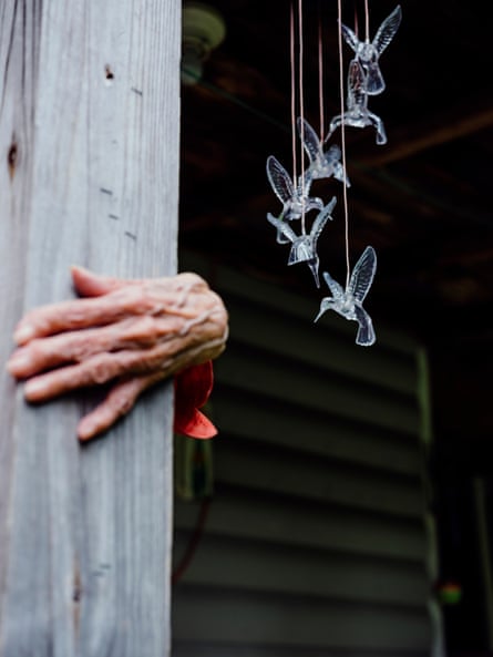 An elderly woman holds onto a post for support on the porch outside her home in Webster county, West Virginia.