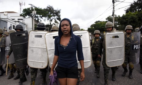 Military police stand guard next to supporters of opposition candidate Salvador Nasralla as they hold a protest march on Wednesday in Tegucigalpa.