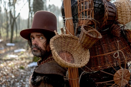 A man with a big brown hat and baskets tied to his back
