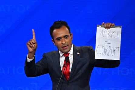Vivek Ramaswamy holds up a sign at the fourth Republican presidential primary debate.