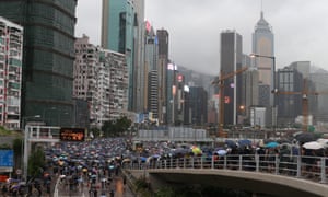 Protesters holding umbrellas march