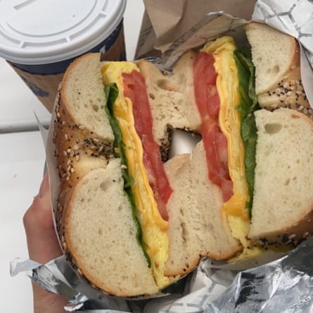 hand holding an egg and cheese bagel