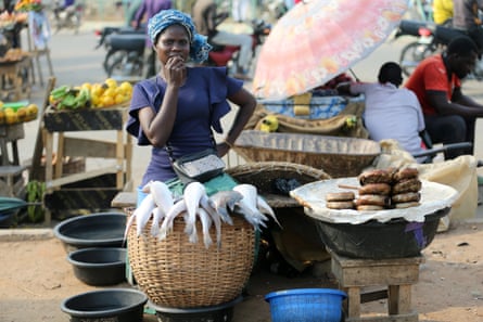 A woman selling fish waits for customers at a roadside market in the Ojodu district in Lagos.