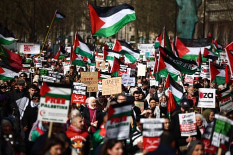 Pro-Palestinian activists and supporters wave flags and carry placards on a march through London, during a National Day of Action for Palestine on Saturday.