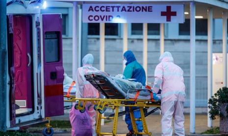 A patient on a stretcher is transported by medical workers wearing protective suits at the Columbus hospital unit of the Gemelli hospital in Rome.