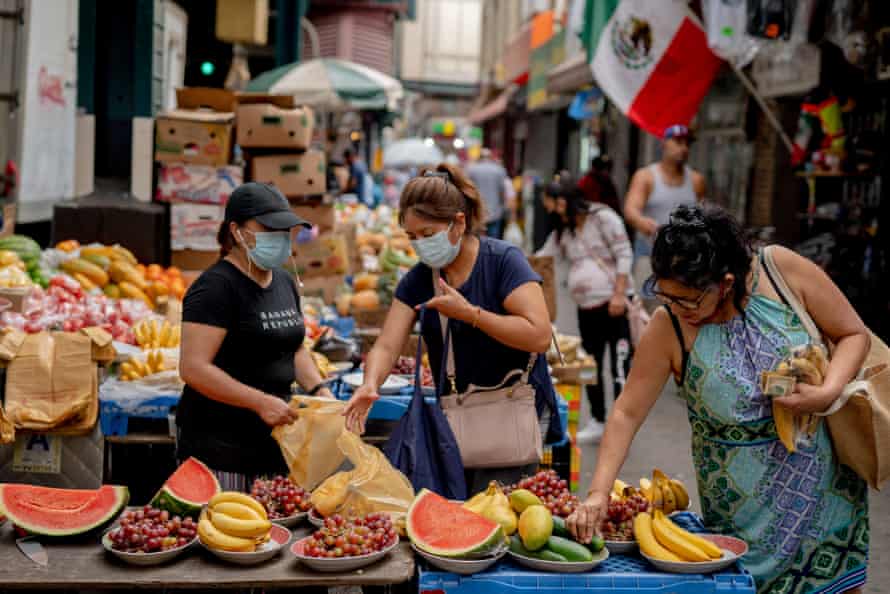 Customers shop for fruit at a street vendor in Corona neighborhood in the Queens borough of New York, U.S., on Saturday, June 27, 2020.