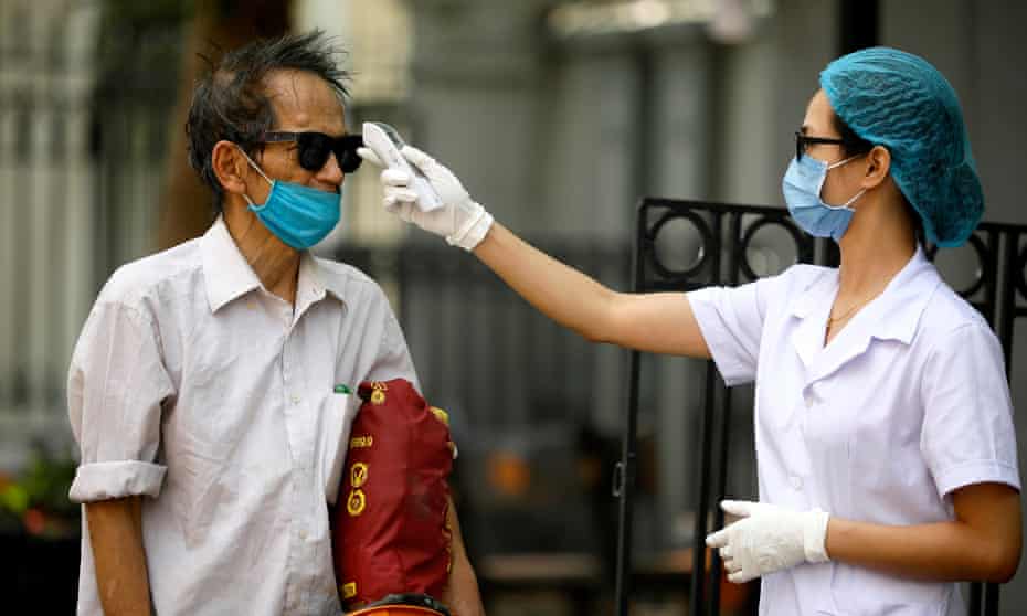 A man has his temperature checked in Hanoi, Vietnam.
