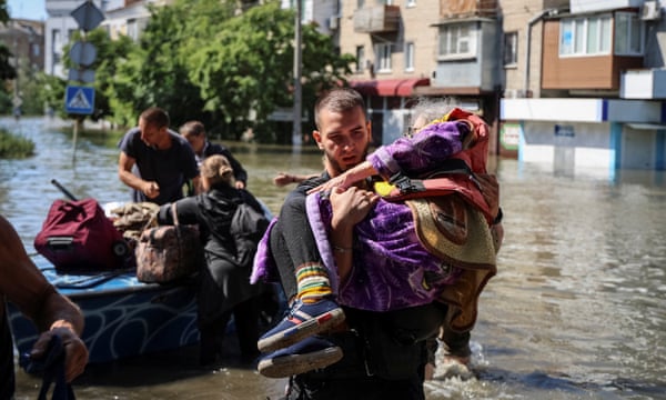 Police evacuate local residents from a flooded area after the Nova Kakhovka dam breached, in Kherson.