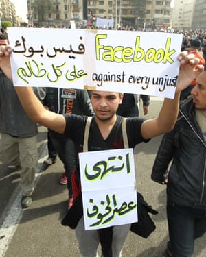An Egyptian holds up a sign praising Facebook, joining others in Cairo’s Tahrir Square in February 2011.