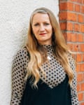 Mid portrait of a woman with long fair hair and a multi print black and white dress with high neck