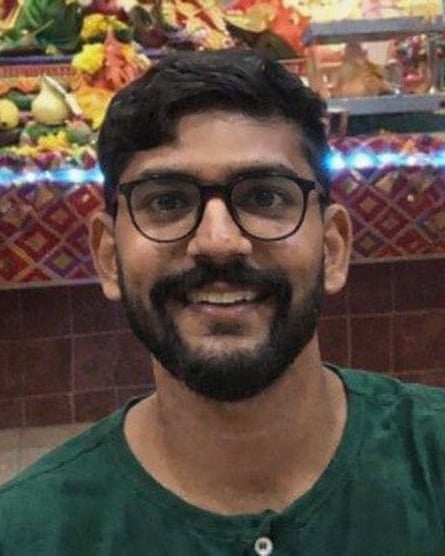 A young south Asian man grinning at the camera