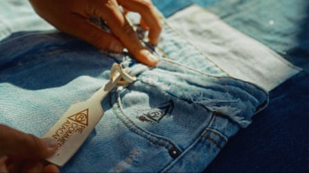 A sales tag is attached to a pair of jeans