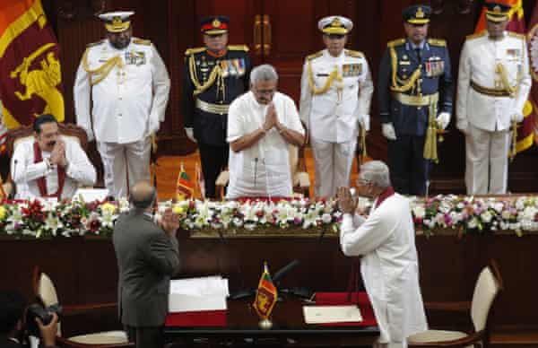 President Gotabaya Rajapaksa, centre, greets his elder brother Chamal Rajapaksa, after swearing him in as agriculture and trade minister, in Colombo on 22 November.