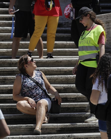 A police officer tells a woman not to sit on the Spanish Steps
