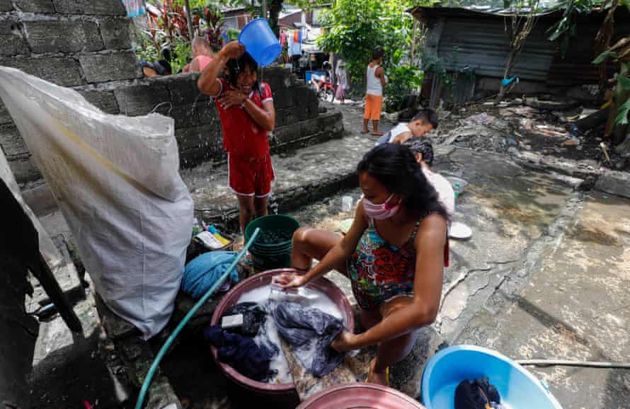 Women wash clothes at their home in Quezon City, Metro Manila, Philippines, August 2020.