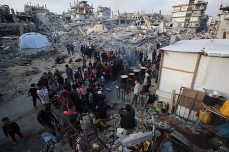 Palestinians wait to receive food relief during Ramadan in Gaza City.