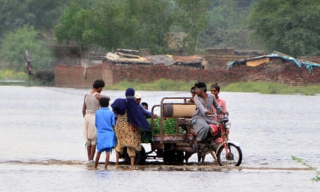 People in the town of Tando Allahayar, in Pakistan's Sindh province, moving to safety after flooding in the area