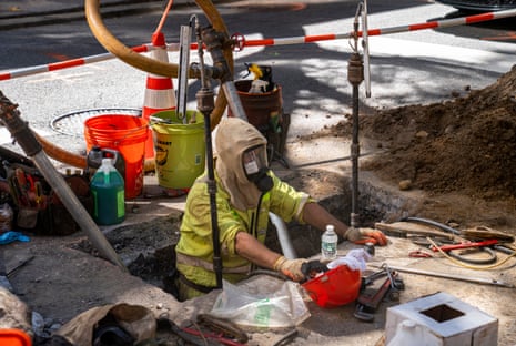 a worker stands in a hole in the ground