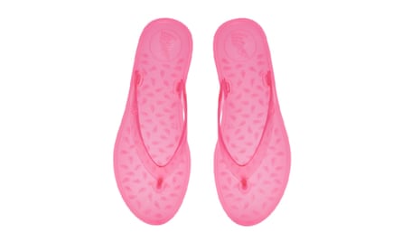 A pair of pink jelly flip-flops on a white background