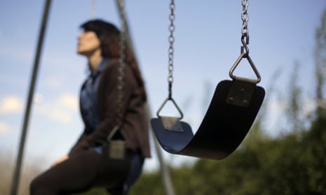Woman sits alone on a swing with an empty one beside her