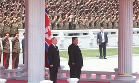 Putin and Kim stand to attention at the ceremony.