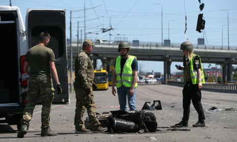 Ukrainian police officers stand next to a part of a missile which landed on a street during a Russian missile strike in Kyiv, Ukraine 29 May 2023, amid Russia's invasion of Ukraine. 