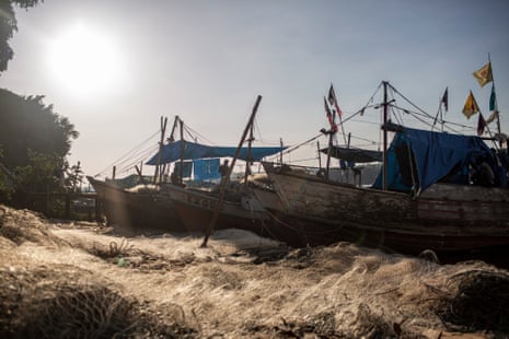 A row of fishing boats on a grassy river bank