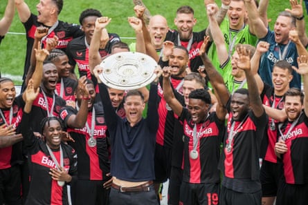 Nathan Tella (No 19) next to Xabi Alonso as Leverkusen celebrate with the Bundesliga trophy.