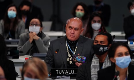 The finance minister from Tuvalu in the South Pacific, Seve Paeniu, holds up an image of his grandchildren during the plenary session.