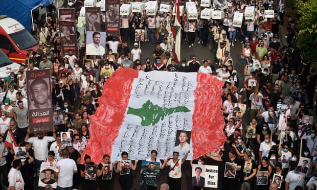 ناشطون يحملون توابيت رمزية وعلم لبنان خلال مسيرة إلى ميناء بيروت لإحياء الذكرى الثانية لانفجار ميناء بيروت.