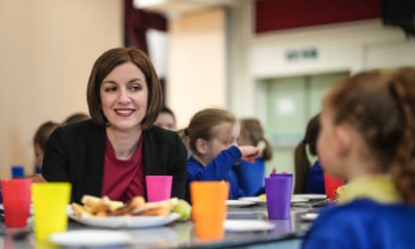 Bridget Phillipson sits at a table with children eating breakfast