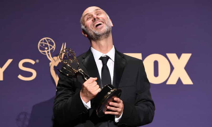 Jesse Armstrong poses, laughing, with his Emmy award for Succession.