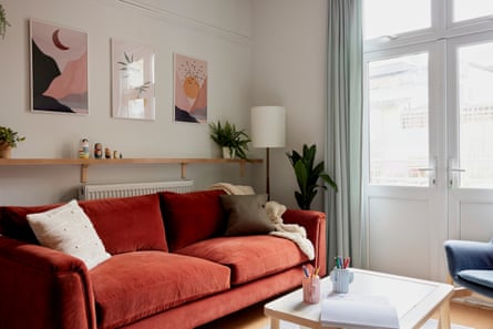 Bright living room with big red sofa and pictures on the wall