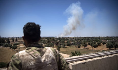 A fighter loyal to the internationally recognised Government of National Accord watches as smoke rises in the distance during clashes with forces loyal to Khalifa Haftar, in Espiaa, about 40km south of Tripoli on 29 April 2019.