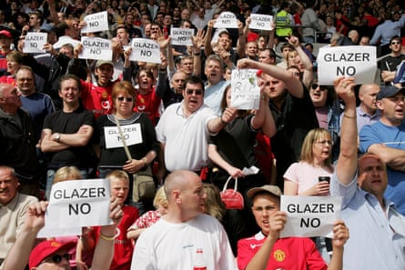 Manchester United fans hold up signs opposing the takeover of the club by Malcolm Glazer during the Premiership match at Southampton in May 2005