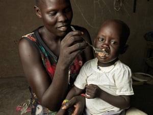 A mother spoon-feeding her baby