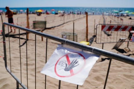 A ‘do not enter’ sign is taped to a temporary fence on a beach