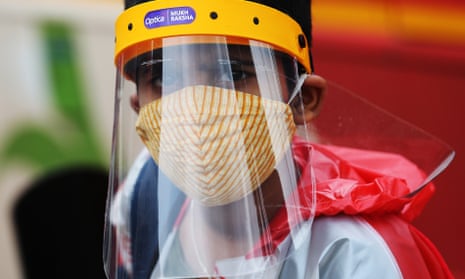 A boy wearing PPE in Bangalore, India, which is going into a one-week lockdown.