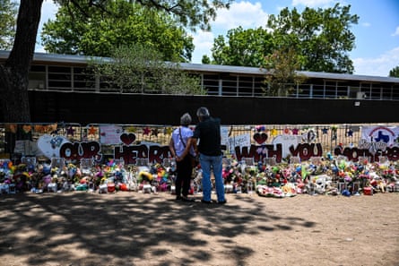 People visit a makeshift memorial to the victims of a shooting at Robb elementary school in Uvalde, Texas.