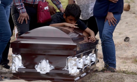 A grandson of the murdered Mexican journalist Carlos Dominguez Rodriguez mourns over his coffin.