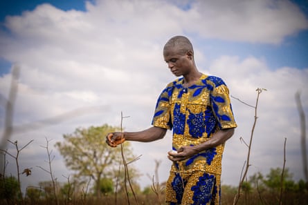 Raphaël Dovonon, 40, holds a ball of leftover cotton in his farmland