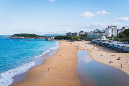 A long-distance look along a sandy beach next to the city