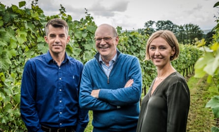 Three people smile at the camera