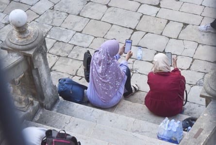 Women in headscarves sit on the steps on a church