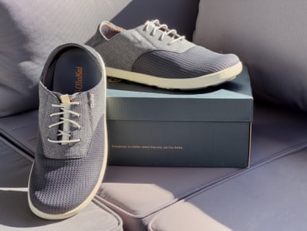 Grey OluKai Nohea Moku men's sneakers next to box on couch