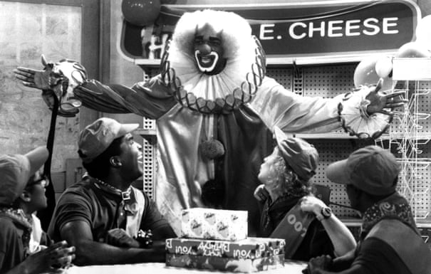 people sitting and looking at a man a clown suit