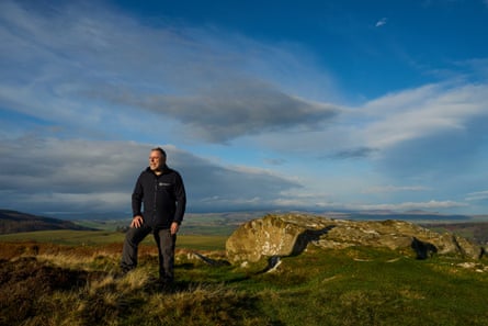 Pratt stands in a rural landscape on a sunny December day