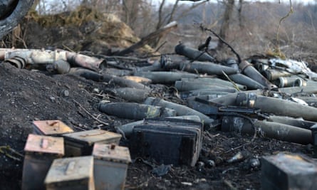 Ammunition including parts of missiles and shells lies on the side of what appears to be a trench or ditch